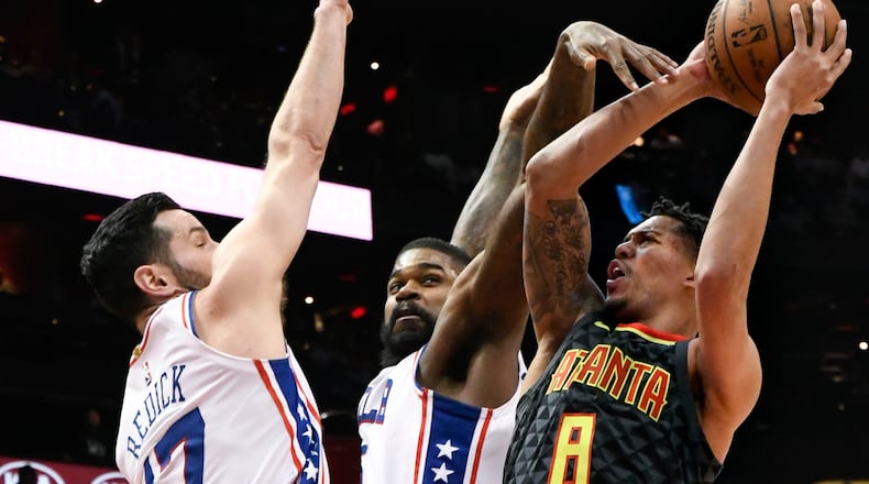Hawks guard Damion Lee shoots as Philadelphia 76ers guard J.J. Redick and center Amir Johnson defend in Tuesday night’s game at Philips Arena.