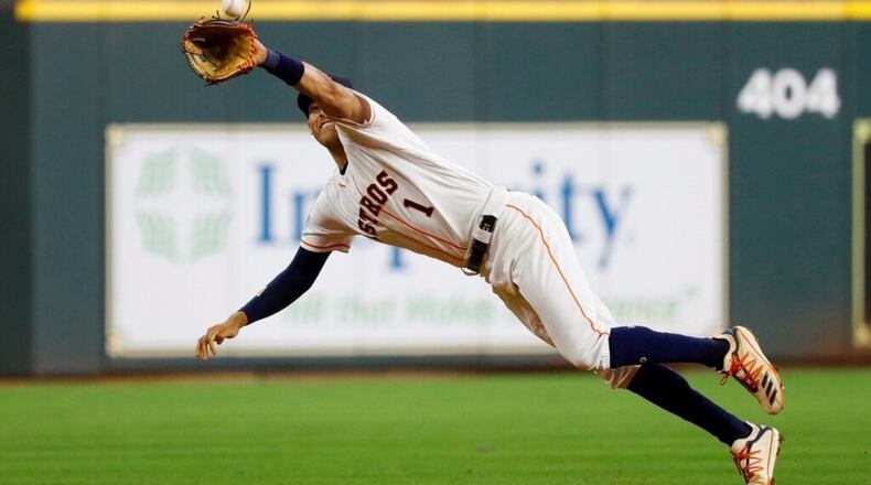 Houston Astros shortstop Carlos Correa catches a line drive by Washington Nationals' Howie Kendrick during the fourth inning of Game 1 of the baseball World Series Tuesday, Oct. 22, 2019, in Houston.