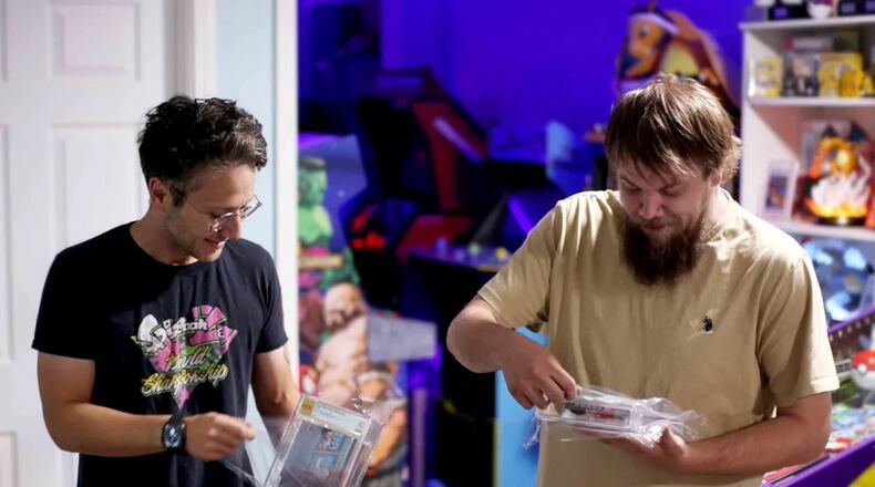 In this photo provided by Nintendo Wire, publisher Jason Ganos, left, and OneStopWonders store owner Kevin Braun hold PSA graded copies of Super Mario Bros. and Duck Hunt video games on Wednesday, June 17, 2026, which they rediscovered in a warehouse in Waukesha, Wis. (Lauren Ganos/Nintendo Wire via AP)