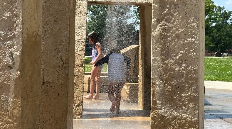 Children play at a water sprayground in Des Moines, Iowa, Monday, June 29, 2026. (AP Photo/Hannah Fingerhut)