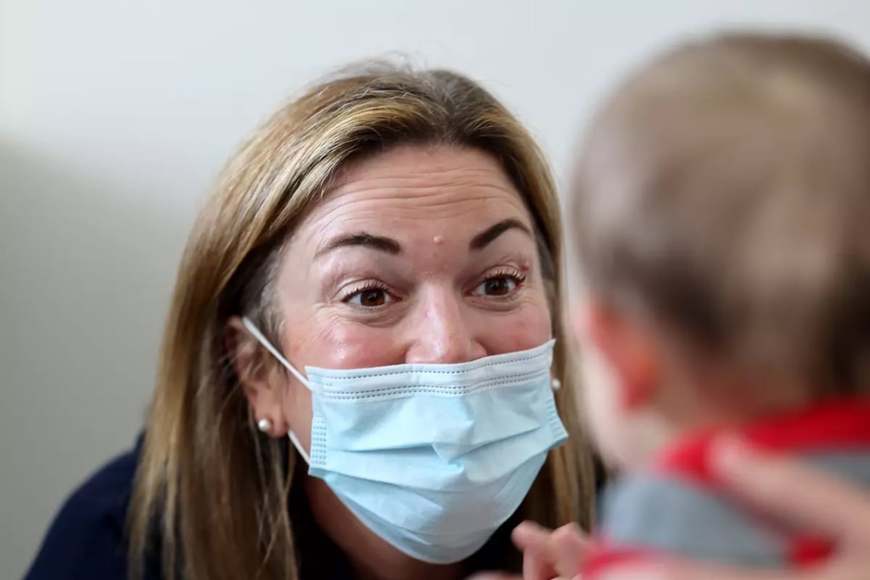 Dr. Neville Anderson (left) interacts with Arlo Vasquez held by his mom Christa Iacono (not pictured) while getting flu, Covid and hepatitis B vaccinations at Larchmont Pediatrics in Los Angeles. (Allen J. Schaben/Los Angeles Times/TNS)