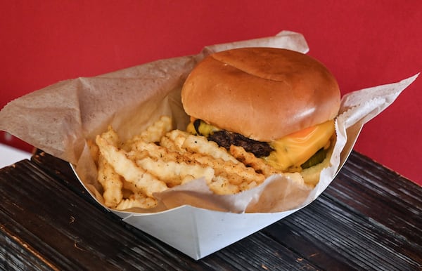 The double stack burger and fries are among the food offerings available from Proof of the Pudding's concession stand, the Hangar, during Atlanta Dream games at the Gateway Center Arena in College Park. (Natrice Miller for the AJC)
