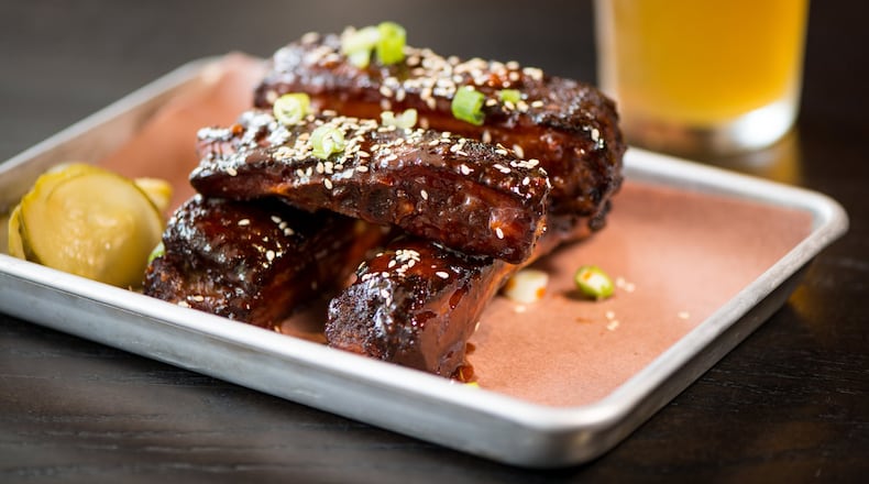 Loyal Tavern Sticky Ribs, smoked pork ribs fried and tossed in sweet and spicy sauce with green onion and sesame seeds. Photo credit- Mia Yakel.