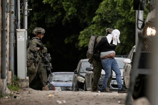 Israeli soldiers arrest a blindfolded Palestinian during an army raid in Nablus, West Bank, on Tuesday, April 8, 2025. (AP Photo/Majdi Mohammed)