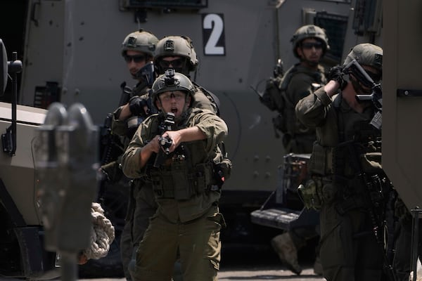An Israeli soldier points his weapon during a military raid in the West Bank city of Nablus, Tuesday, June 10, 2025. (AP Photo/Majdi Mohammed)
