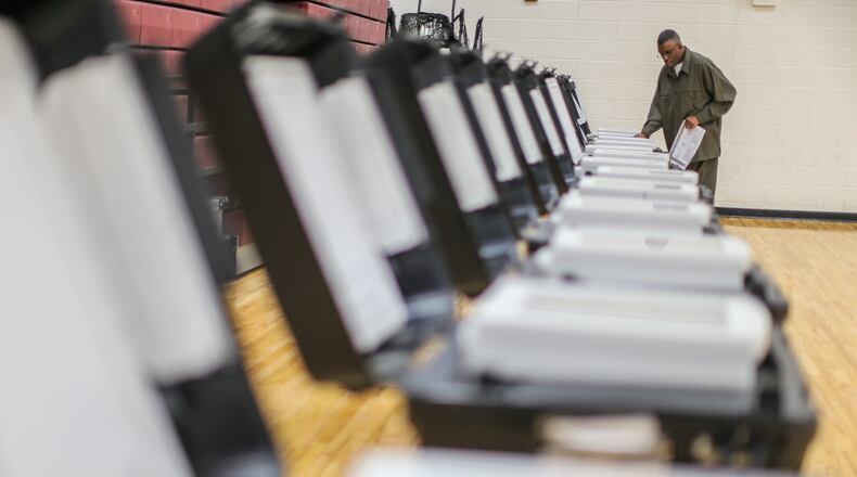 November 8, 2016 Atlanta: Poll manager, Melvin Davis Jr. prepare the voting machines on Tuesday, Nov. 8, 2016 at Henry W. Grady High School at 929 Charles Allen Dr NE in Atlanta. JOHN SPINK /JSPINK@AJC.COM