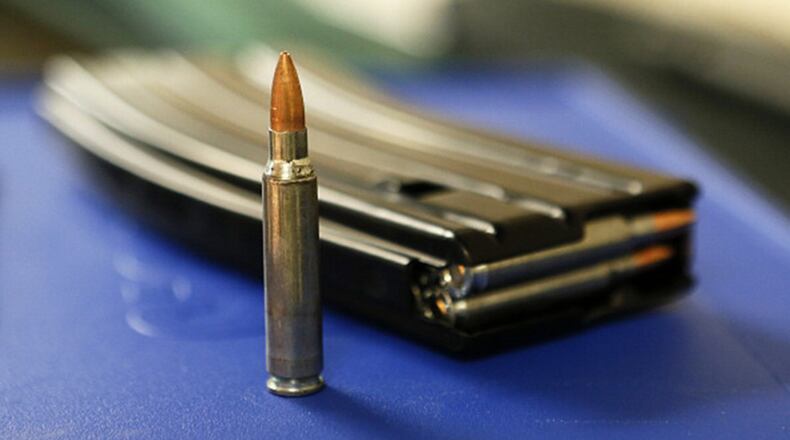 A bullet and high capacity 30-round clip sit on a table at "Get Some Guns & Ammo" shooting range