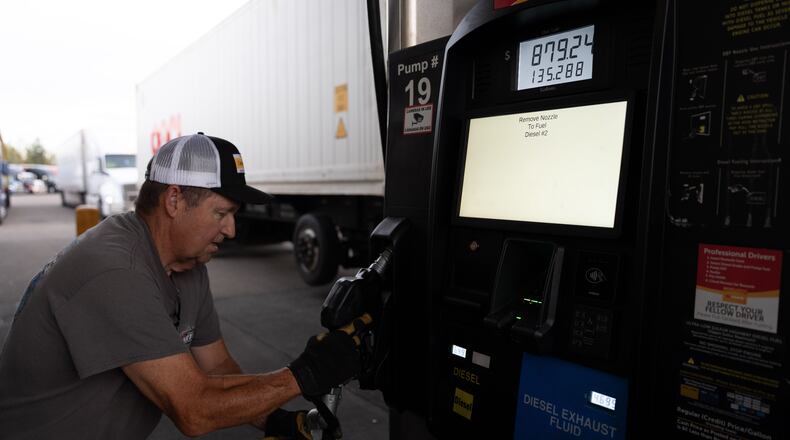 Chuck Byrd puts away a fuel nozzel after filling two tanks for a truck at a gas station on Tuesday, April 7, 2026, in Aurora, Ore. (AP Photo/Jenny Kane)