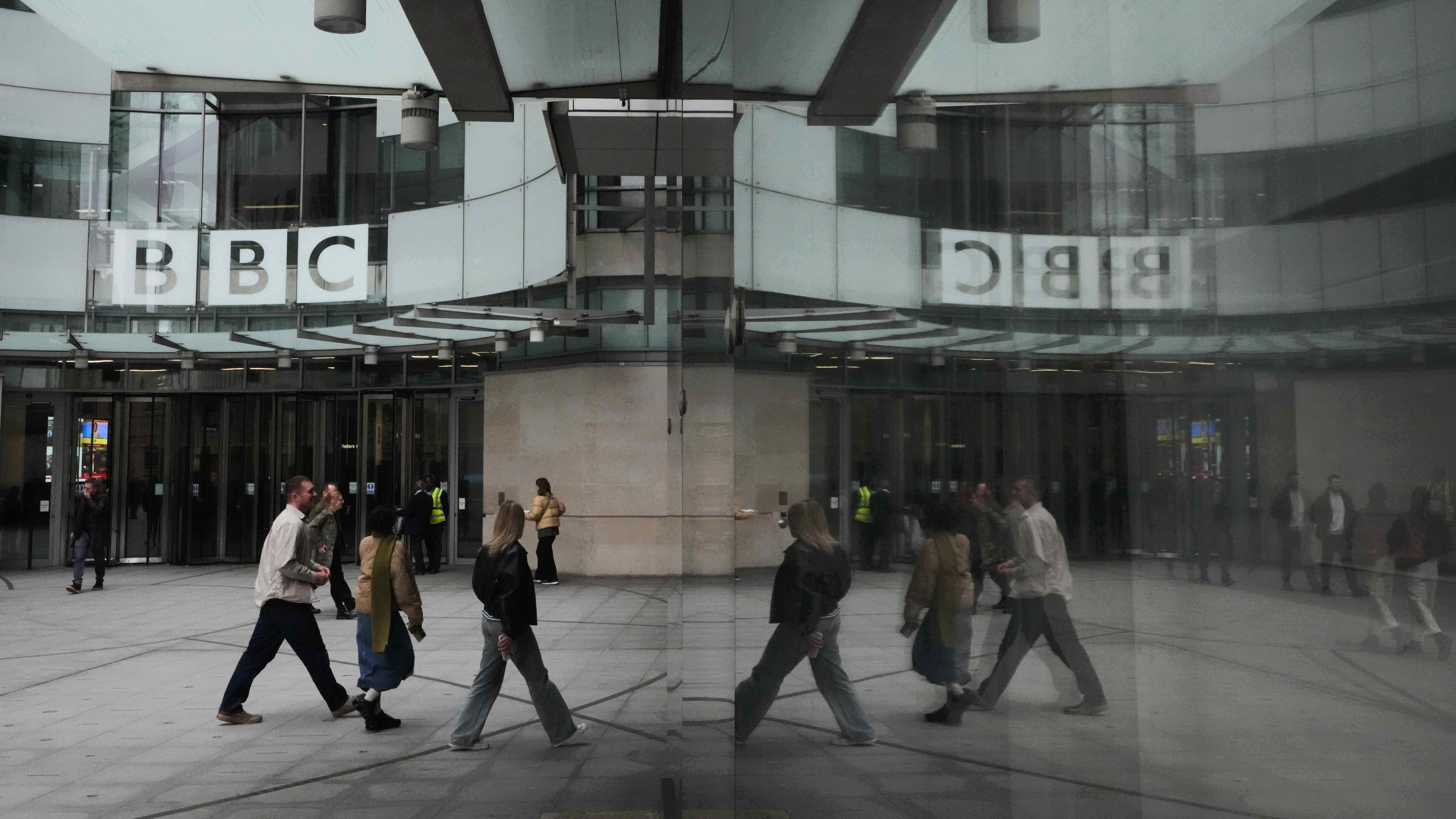 FILE - Pedestrians are reflected as they walk outside BBC Broadcasting House in London, Tuesday, Nov. 11, 2025. (AP Photo/Kirsty Wigglesworth, file)