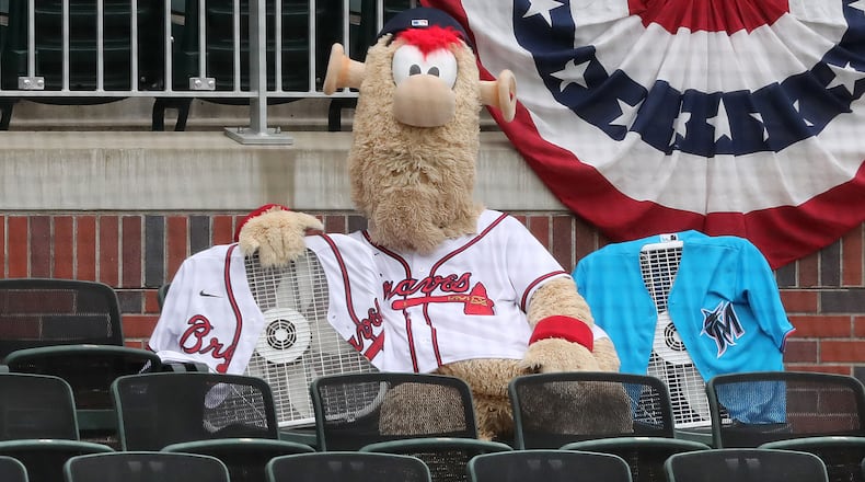 Braves mascot Blooper watches the exhibition game against the Miami Marlins with the only fans in the stands, a Braves fan and a Marlins fan, Wednesday, July 22, 2020, at Truist Park in Atlanta.