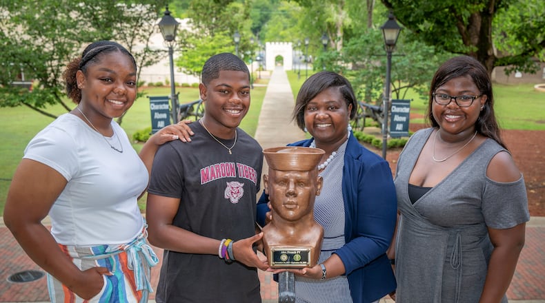 Shanoca French and her three children, Madison (L), Alex, and Alexis (R), stand around a bust of her husband, Alex French, at the Georgia Military College Preparatory School in Milledgeville Wednesday, May 24, 2022. The bust was made by Cliff Leonard, who creates busts of veterans for free as a service to others. (Steve Schaefer / steve.schaefer@ajc.com)