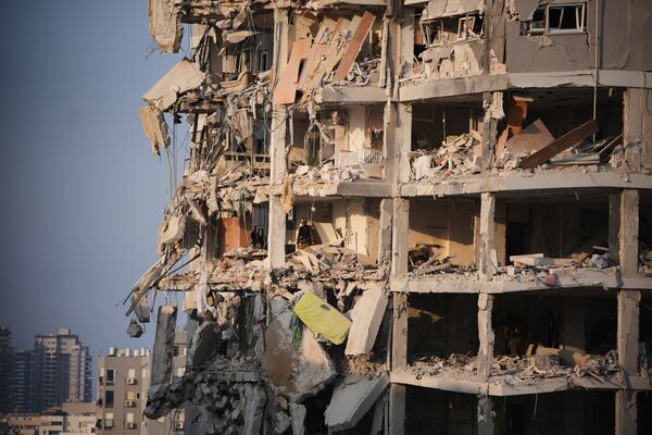 Israeli security forces inspect a destroyed building that was hit by a missile fired from Iran, near Tel Aviv, Israel, Sunday, June 15, 2025. (AP Photo/Ohad Zwigenberg)