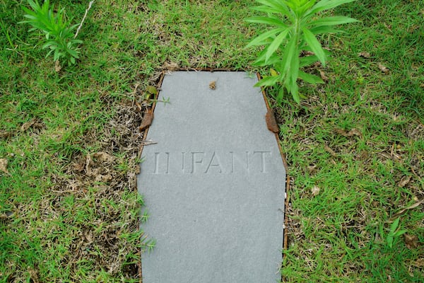 A casket-shaped stone marks an infant's grave at the original site of the First Baptist Church of Williamsburg in Williamsburg, Va., on May 30, 2025. (AP Photo/Allen G. Breed)