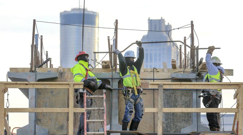 Construction workers early this year working on the Northside Drive Pedestrian Bridge that will connect Mercedes-Benz Stadium and the Vine City MARTA station. JOHN SPINK/JSPINK@AJC.COM