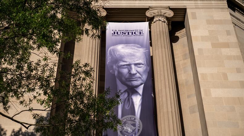 A giant portrait of President Donald Trump looks down from the Justice Department in Washington, Tuesday, June 2, 2026. The Justice Department said it would comply with a court order pausing the implementation of a $1.776 billion settlement fund designed to compensate President Donald Trump's political allies after GOP senators revolted. (AP Photo/J. Scott Applewhite)