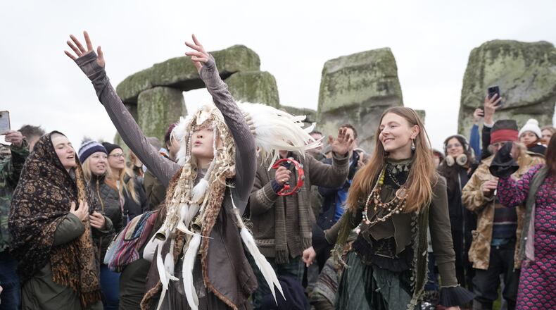 People take part in the winter solstice celebrations during sunrise at the Stonehenge prehistoric monument on Salisbury Plain in Wiltshire, England, Sunday, Dec. 21, 2025. (Andrew Matthew/PA via AP)