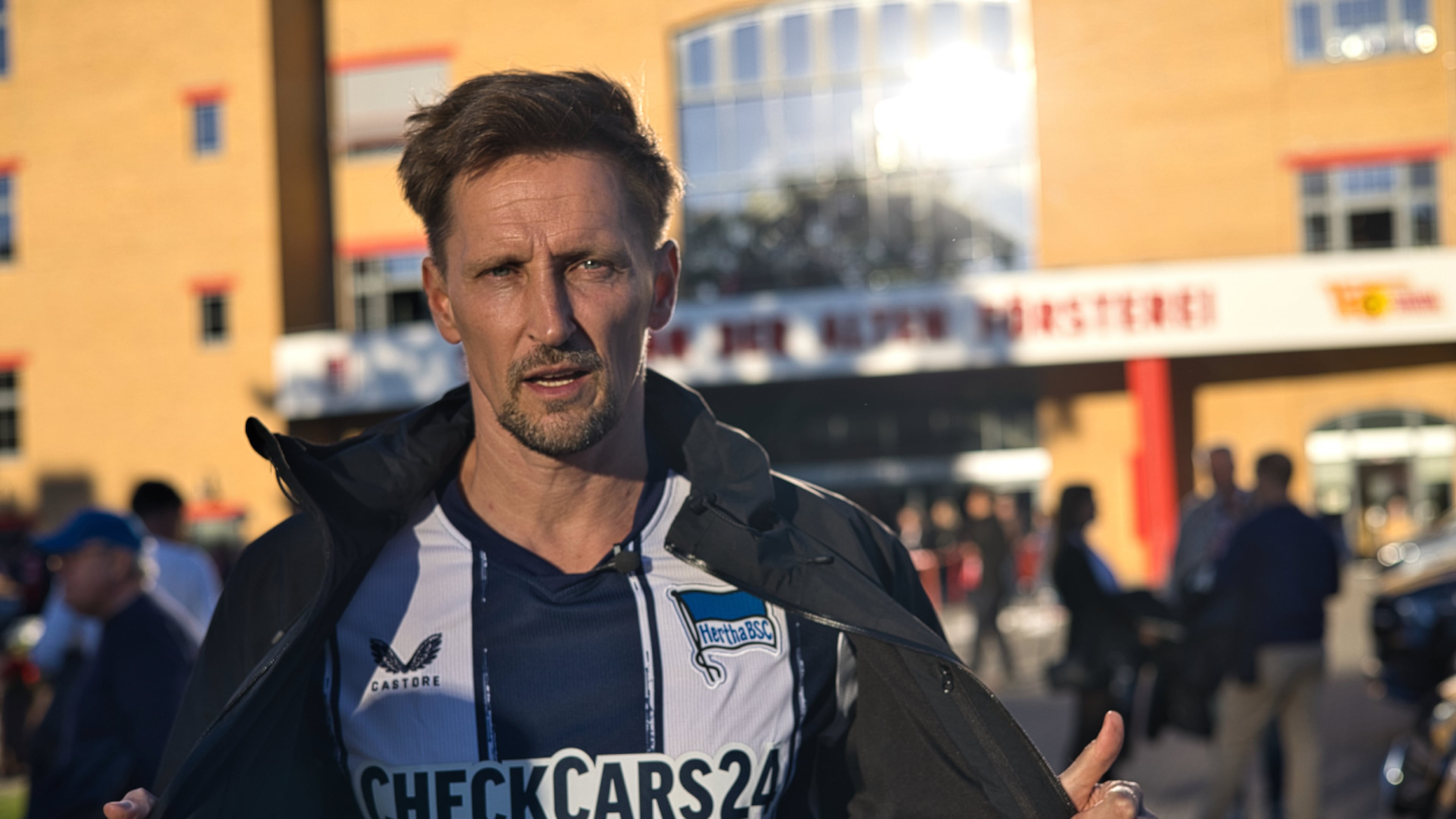 Thomas Melchior unveils a Hertha Berlin jersey before he tries to talk to Union Berlin fans about sports betting in Köpenick, Berlin, Sunday, Sept. 28, 2025. (AP Photo/Ciaran Fahey)