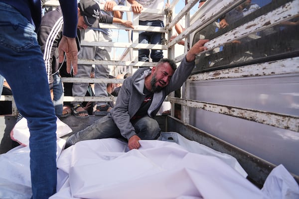 Osama Abu Mosabbah, mourns his wife and two children who were killed in an Israeli army airstrike on the Gaza Strip, during their funeral at Al-Aqsa Hospital in Deir al-Balah, Gaza, Tuesday, May 20, 2025. (AP Photo/Abdel Kareem Hana)