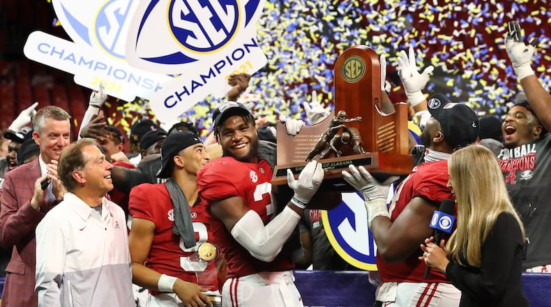 Alabama coach Nick Saban (from left) looks on with MVP quarterback Bryce Young as Will Anderson and Phildarian Mathis lift the SEC championship trophy after beating Georgia 41-24 on Saturday, Dec 4, 2021, in Atlanta. “Curtis Compton / Curtis.Compton@ajc.com”`