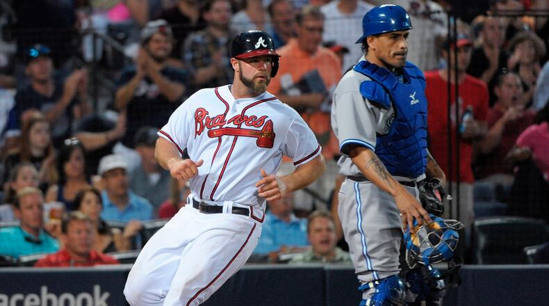 Atlanta Braves' Evan Gattis scores past Toronto Blue Jays catcher Henry Blanco on the single by Ramiro Pena in the sixth inning of a baseball game at Turner Field in Atlanta, Thursday, May 30, 2013.