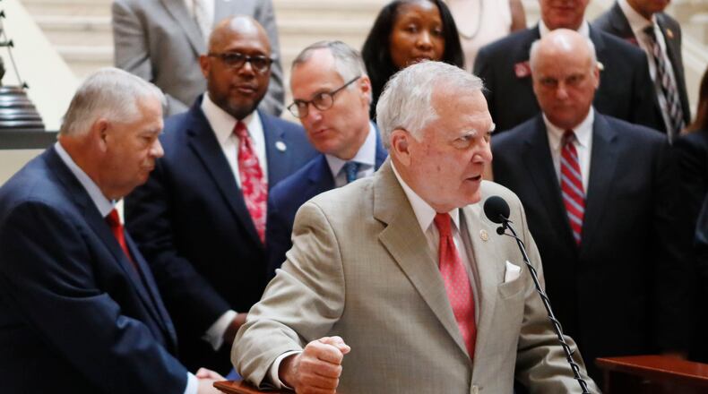 Gov. Nathan Deal, flanked by House Speaker David Ralston (left), Lt. Gov. Casey Cagle, and other legislators, announce plans for $100 million of capital spending on a proposed bus rapid transit line and express lanes along Ga. 400. BOB ANDRES /BANDRES@AJC.COM