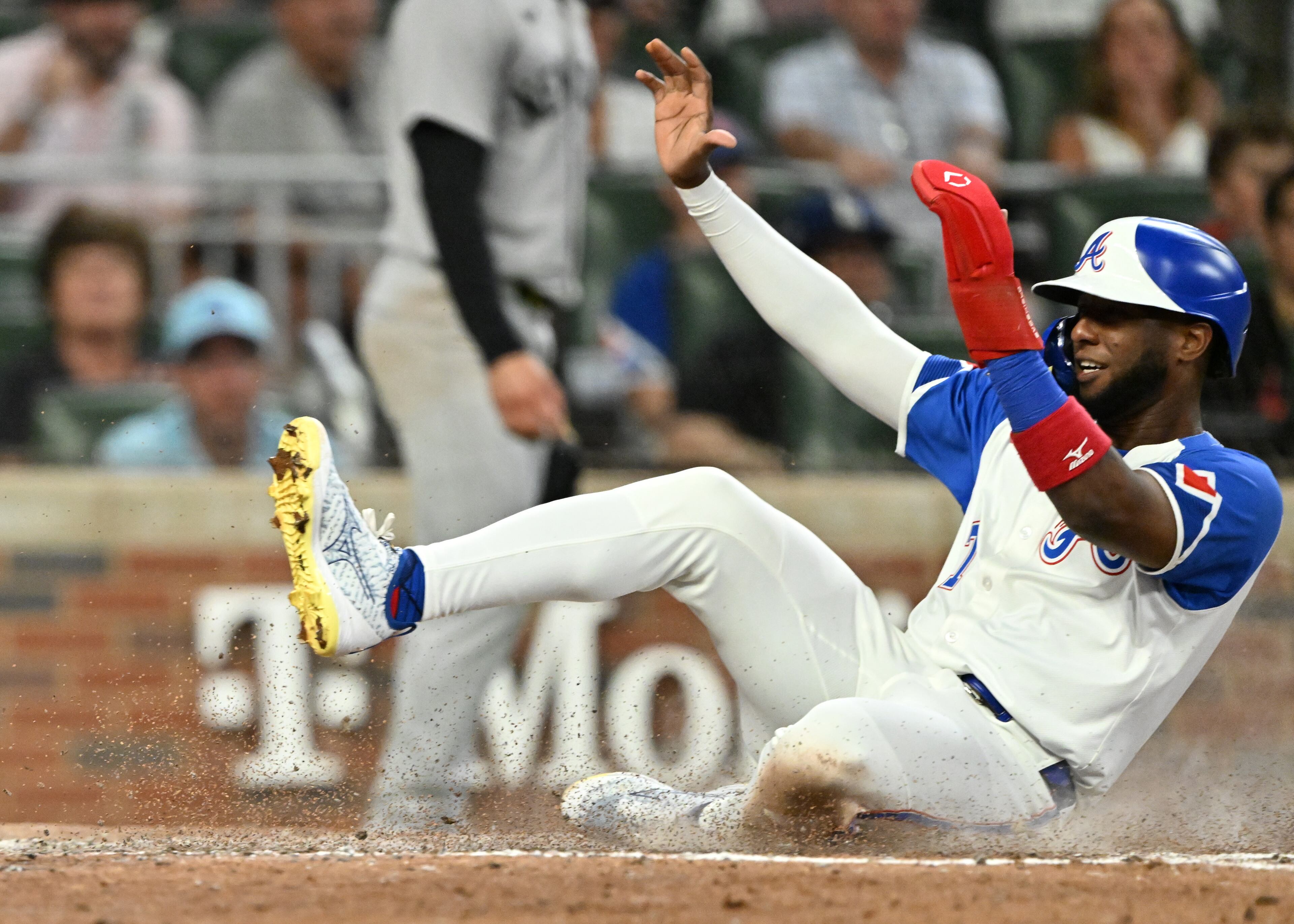 Atlanta Braves outfielder Jurickson Profar (7) slides into home base safely on an RBI single by Atlanta Braves first base Matt Olson (28) during the sixth inning of a baseball game at Truist Park, Saturday, July 19, 2025, in Atlanta. New York Yankees won 12-9 over Atlanta Braves. (Hyosub Shin / AJC)