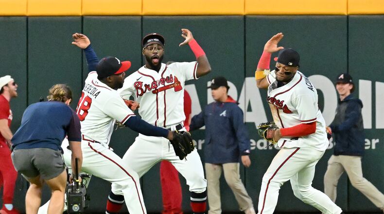 Braves outfielders (from left) Guillermo Heredia, Michael Harris II and Ronald Acuna celebrate their 5-3 victory over the Mets at Truist Park on Sunday, Oct. 2, 2022.  (Hyosub Shin / Hyosub.Shin@ajc.com)