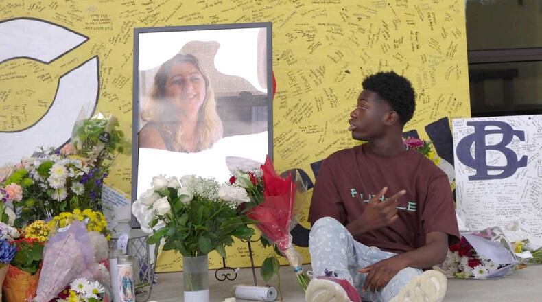 Apalachee High School student Isaac Sanguma stares at a picture of Cristina Irimie, a teacher at his school who was killed in a Sept. 4 shooting at the school. Isaac wrote a song about the incident. (April Lanuza/The Atlanta Journal-Constitution)