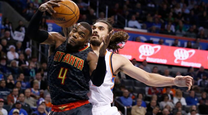 Atlanta Hawks forward Paul Millsap (4) grabs a rebound in front of Oklahoma City Thunder center Steven Adams, right, in the first half of an NBA basketball game in Oklahoma City, Monday, Dec. 19, 2016. (AP Photo/Sue Ogrocki)