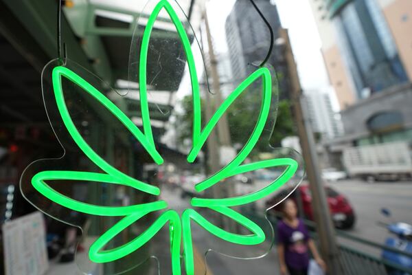 A pedestrian walks by the sign of a Cannabis shop after Thailand started banning the sale of cannabis to those without a prescription in Bangkok, Thailand, Friday, June 27, 2025. (AP Photo/Sakchai Lalit)