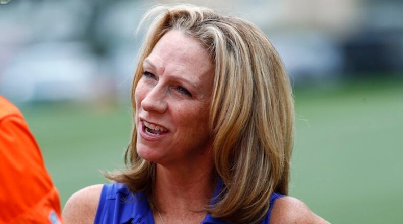 In this Saturday, July 29, 2017, photograph, sports anouncer Beth Mowins chats with a reporter while watching the Denver Broncos run through drills at an NFL football training camp in Englewood, Colo. While Mowins is focused on football, she will become the first woman since 1987 to be the lead announcer on a nationally televised, regular season NFL game. (AP Photo/David Zalubowski)