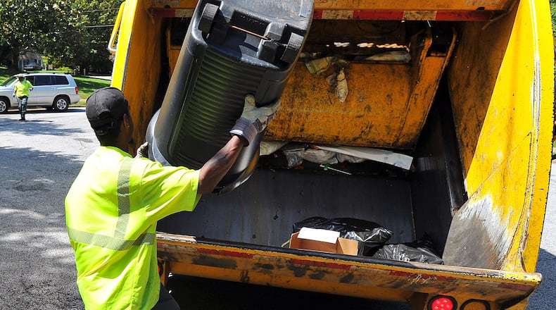 DeKalb County sanitation worker Larry Wyatt dumps trash into the truck.