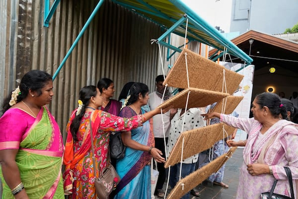 Daily wage workers, who mostly work outdoors, explore Neralu, an innovative portable heat shelter, at the Sweat and Concrete 2025 event in Bengaluru, India, Thursday, May 29, 2025. (AP Photo/Aijaz Rahi)