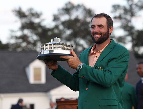 Scottie Scheffler holds the Masters Champion trophy at Augusta National Golf Club, Sunday, April 14, 2024, in Augusta. (Jason Getz/AJC)