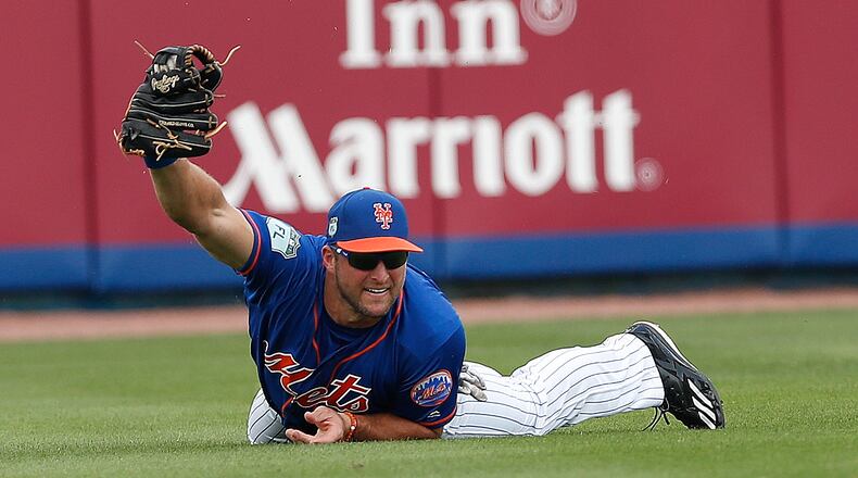 New York Mets left fielder Tim Tebow makes a diving catch on a fly ball by Miami Marlins' Justin Bour in the second inning of a spring training baseball game Monday, March 13, 2017, in Port St. Lucie, Fla.