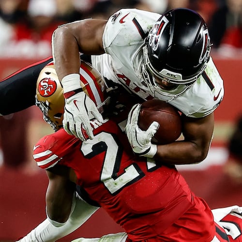 San Francisco 49ers safety Ji'Ayir Brown tackles Atlanta Falcons running back Bijan Robinson in the second half of Sunday's game. Robinson was held to less than 100 yards in the game. (Kelley L Cox/AP)