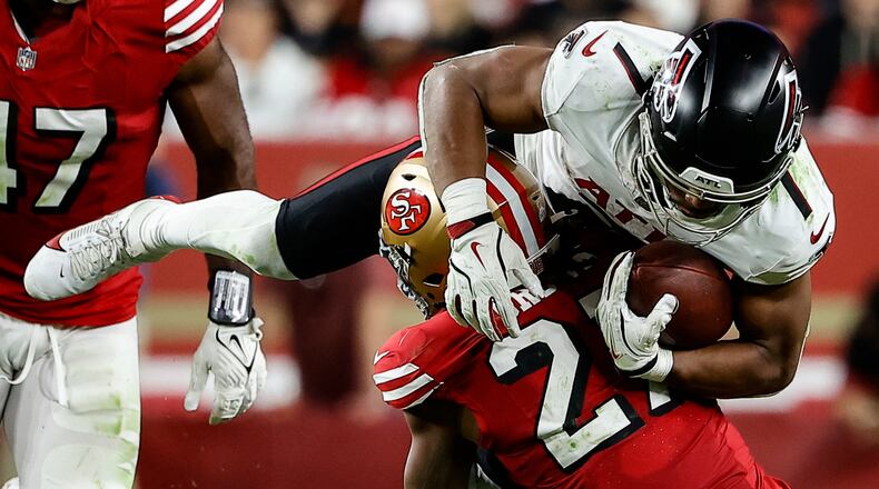 San Francisco 49ers safety Ji'Ayir Brown tackles Atlanta Falcons running back Bijan Robinson in the second half of Sunday's game. Robinson was held to less than 100 yards in the game. (Kelley L Cox/AP)
