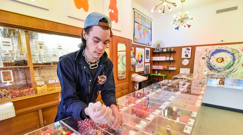 Christian Farquis serves up some candy at Henry's Candy Company Friday, April 5, 2019 on High Street i downtown Hamilton. Henry's Candy Shop offers bulk candy and chocolates. NICK GRAHAM/STAFF