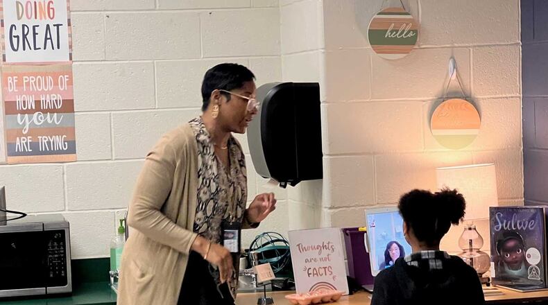 Bolton Academy school social worker Cilia Miles demonstrates the telehealth services with Kori Thompson, 9, a third-grader. (Eric Stirgus/eric.stirgus@ajc.com)