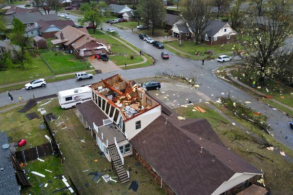 An early morning severe storm damaged homes, destroying the roofs and knocked down power lines, trees, and fences off 96th Street North near Garnett Road, Wednesday, April 2, 2025, in Owasso, Okla. (Mike Simons/Tulsa World via AP)