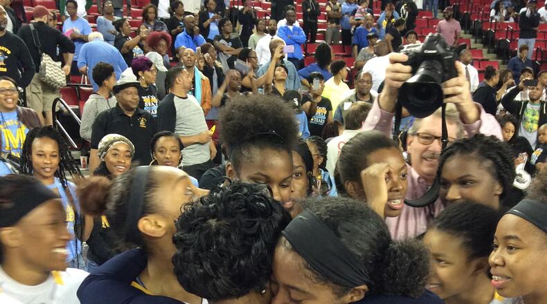 Mays coach Chantay Frost celebrates with players after their 52-51 victory over Harrison in the Class AAAAAA championship game at Stegeman Coliseum.