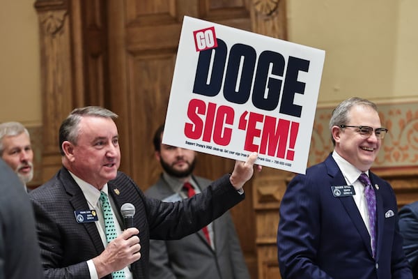 Sen. Frank Ginn, R-Danielsville, holds up a sign that reads "Go DOGE Sic ‘em!" in the Senate chambers during Crossover Day at the state Capitol on Thursday, March 6, 2025, in Atlanta. (Natrice Miller/AJC)
