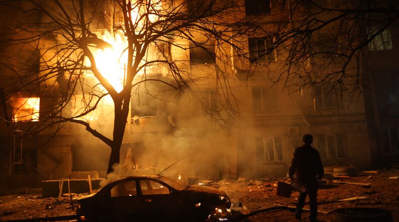 A man walks in front of burning residential building after a Russian attack on Zaporizhzhia, Ukraine, Wednesday, Nov. 26, 2025. (AP Photo/Kateryna Klochko)