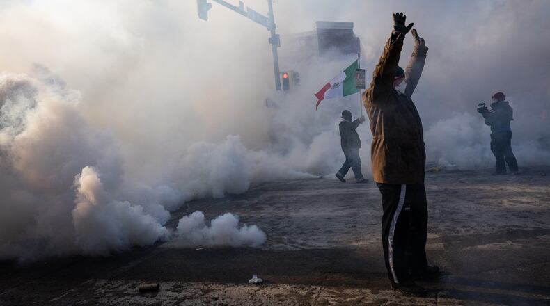 A person holds up their hands as law enforcement deploys a thick screen of teargas on Nicollet Avenue in Minneapolis on Saturday, Jan. 24, 2026. (Ben Hovland/Minnesota Public Radio via AP)