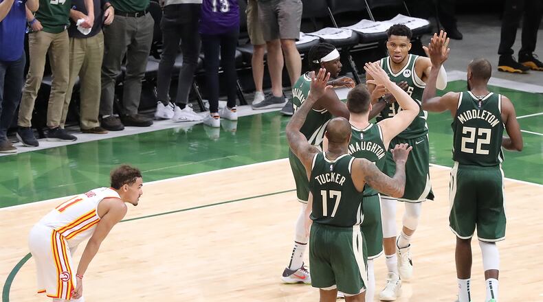 062321 Milwaukee: Atlanta Hawks guard Trae Young looks on as Milwaukee Bucks forward Giannis Antetokounmpo gets five from teammate after scoring and drawing a foul to take a 102-98 lead over the Hawks with 4:31 left to play in game 1 of the NBA Eastern Conference Finals on Wednesday, June 23, 2021, in Milwaukee. The young and relentless Hawks rallied in the final minutes for a 116-113 victory over the Bucks. “Curtis Compton / Curtis.Compton@ajc.com”