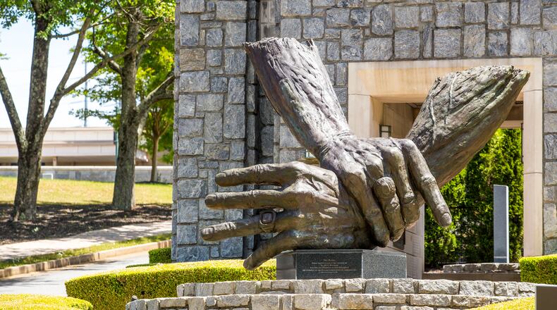 At Marietta's Life University, the nation's largest chiropractic school, a traditional, philosophy-based form of chiropractic dominates, promoting spinal adjustments and healthy living as the best protections against disease. Seen here is the campus's sculpture of the hands of founder Sid Williams. (Jenni Girtman for The Atlanta Journal Constitution)
