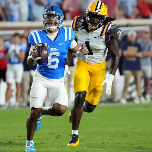 Mississippi quarterback Trinidad Chambliss (6) is pursued by LSU defensive end Princewill Umanmielen (1) during the first half of an NCAA college football game in Oxford, Miss., Saturday, Sept. 19, 2026. (AP Photo/Rogelio V. Solis)