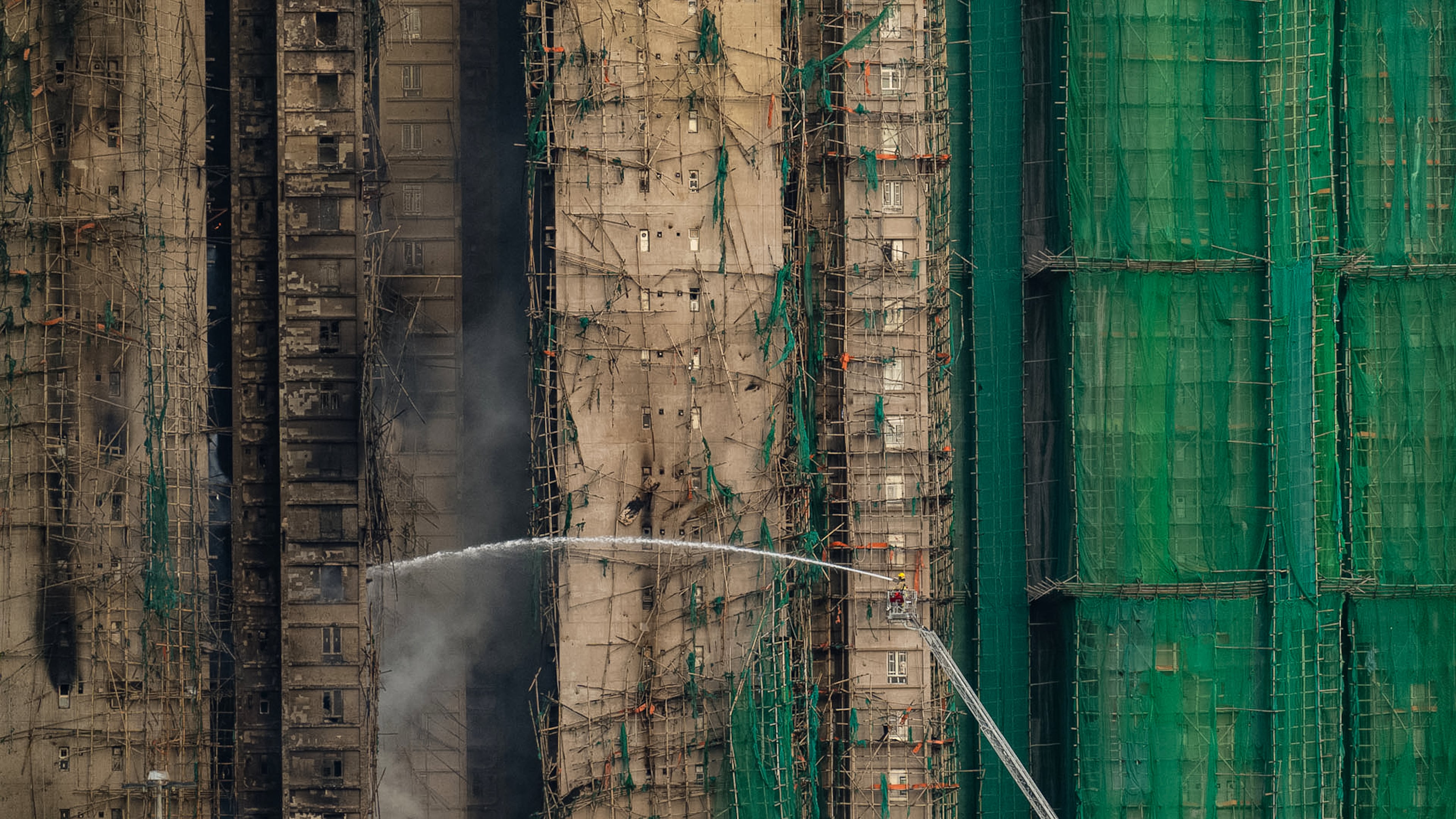 Firefighters work to extinguish a fire which broke out Wednesday at Wang Fuk Court, a residential estate in the Tai Po district of Hong Kong's New Territories, Thursday, Nov. 27, 2025. (AP Photo/Chan Long Hei)