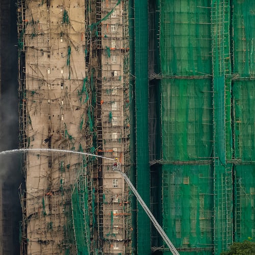 Firefighters work to extinguish a fire which broke out Wednesday at Wang Fuk Court, a residential estate in the Tai Po district of Hong Kong's New Territories, Thursday, Nov. 27, 2025. (AP Photo/Chan Long Hei)