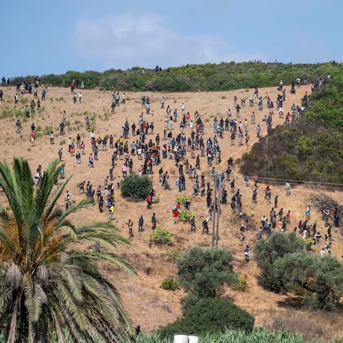 Migrants gather on a hill as they attempt crossing from the border town of Fnideq to the Spanish enclave of Ceuta, Saturday, Aug. 15, 2026. (AP Photo)